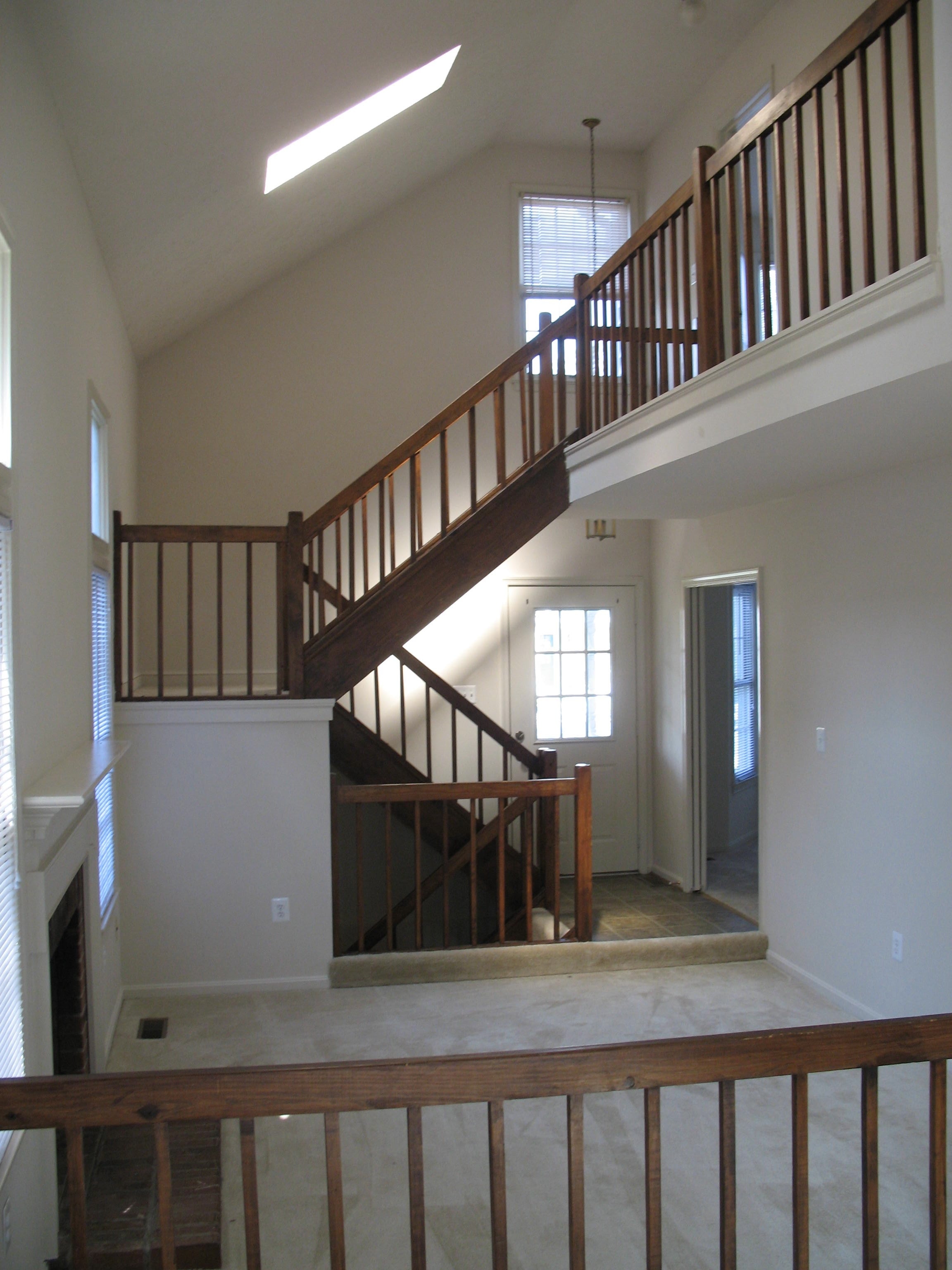 A wooden staircase with a railing leads up to a second floor.