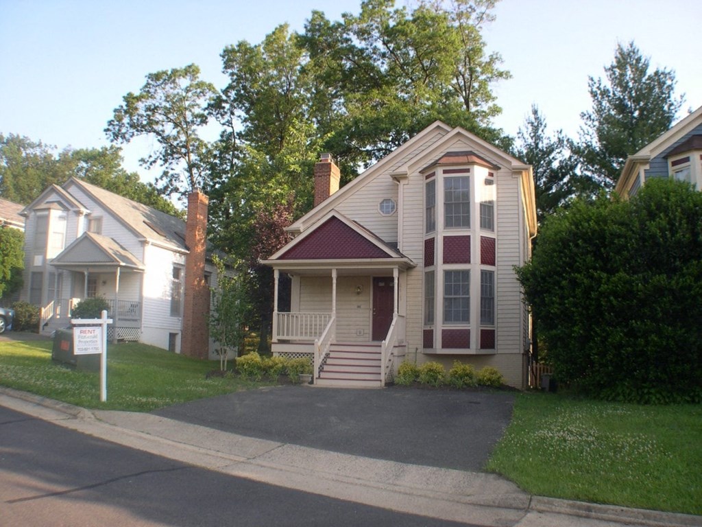 A house with a red door and a white sign in front.