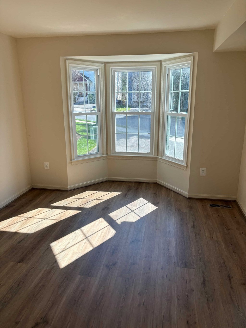 A room with a large window and wooden flooring.
