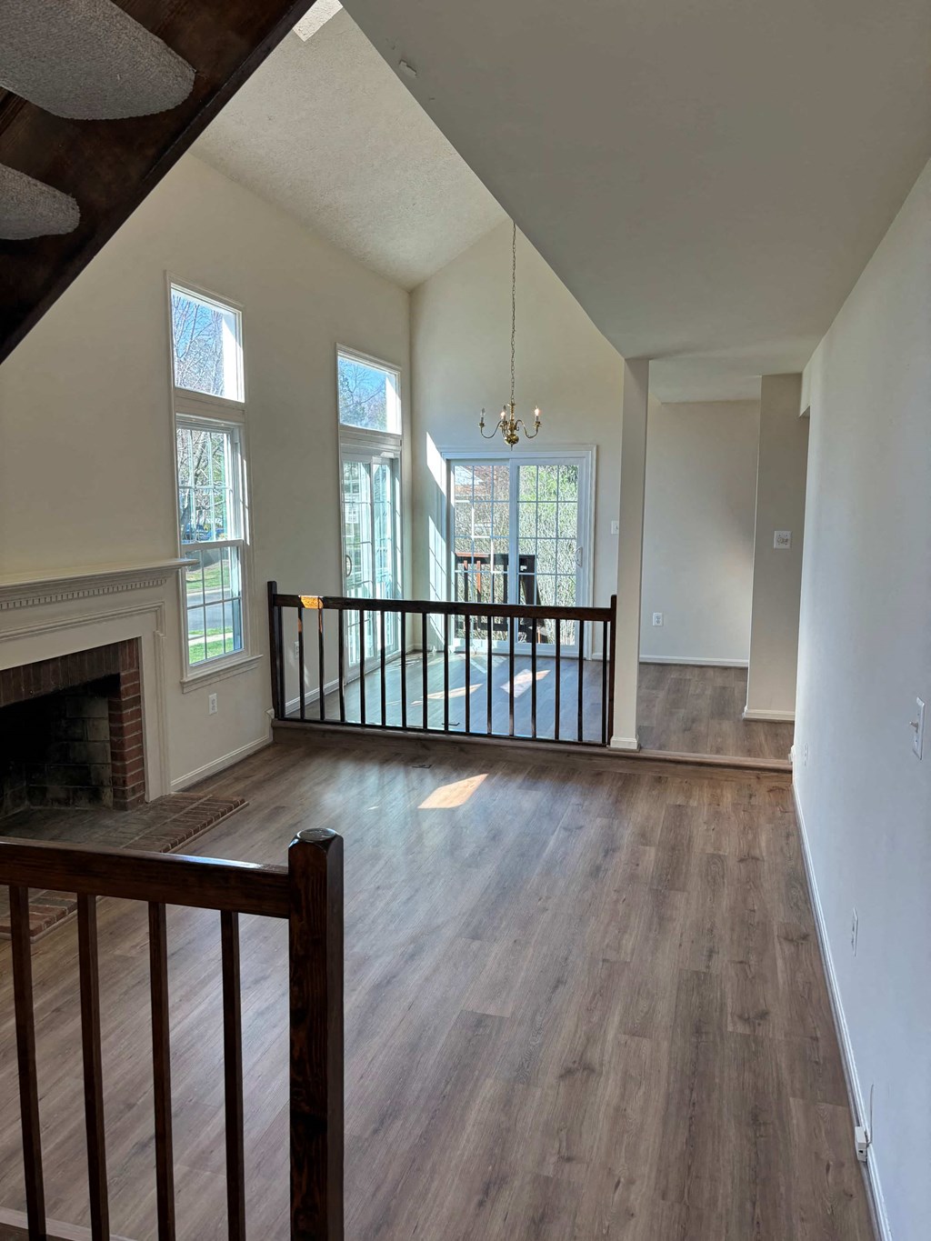 A large, empty room with wooden floors and a fireplace.