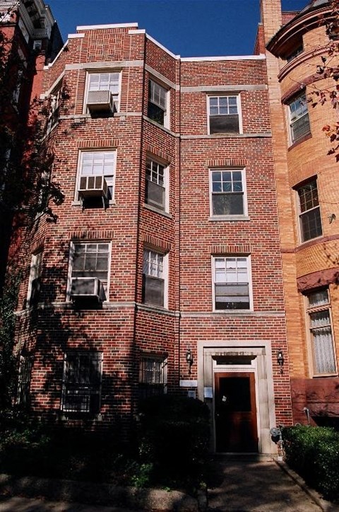 A red brick building with a black door and windows.