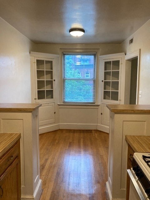 A kitchen with wooden floors and white walls.