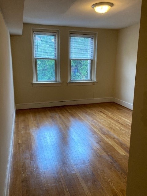 A room with wooden floors and two windows.
