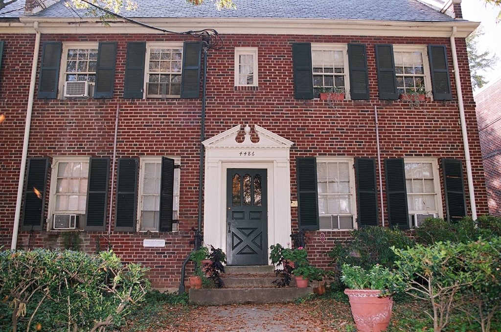 A red brick house with a black door and windows.