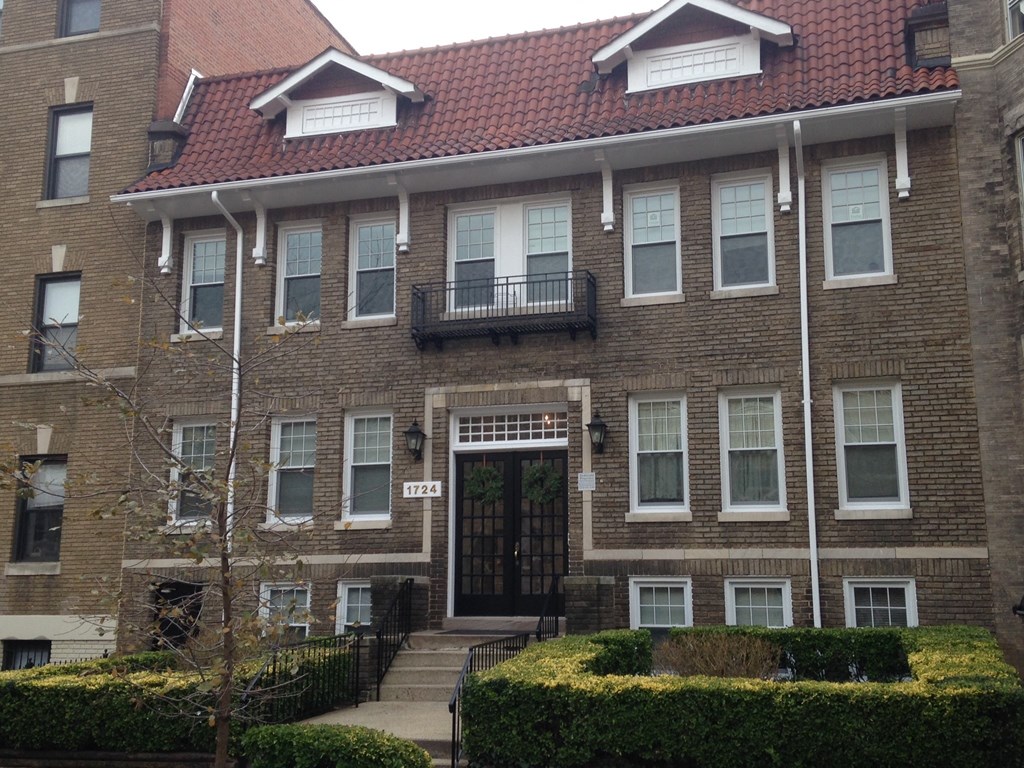 A brick building with a black gate in front.