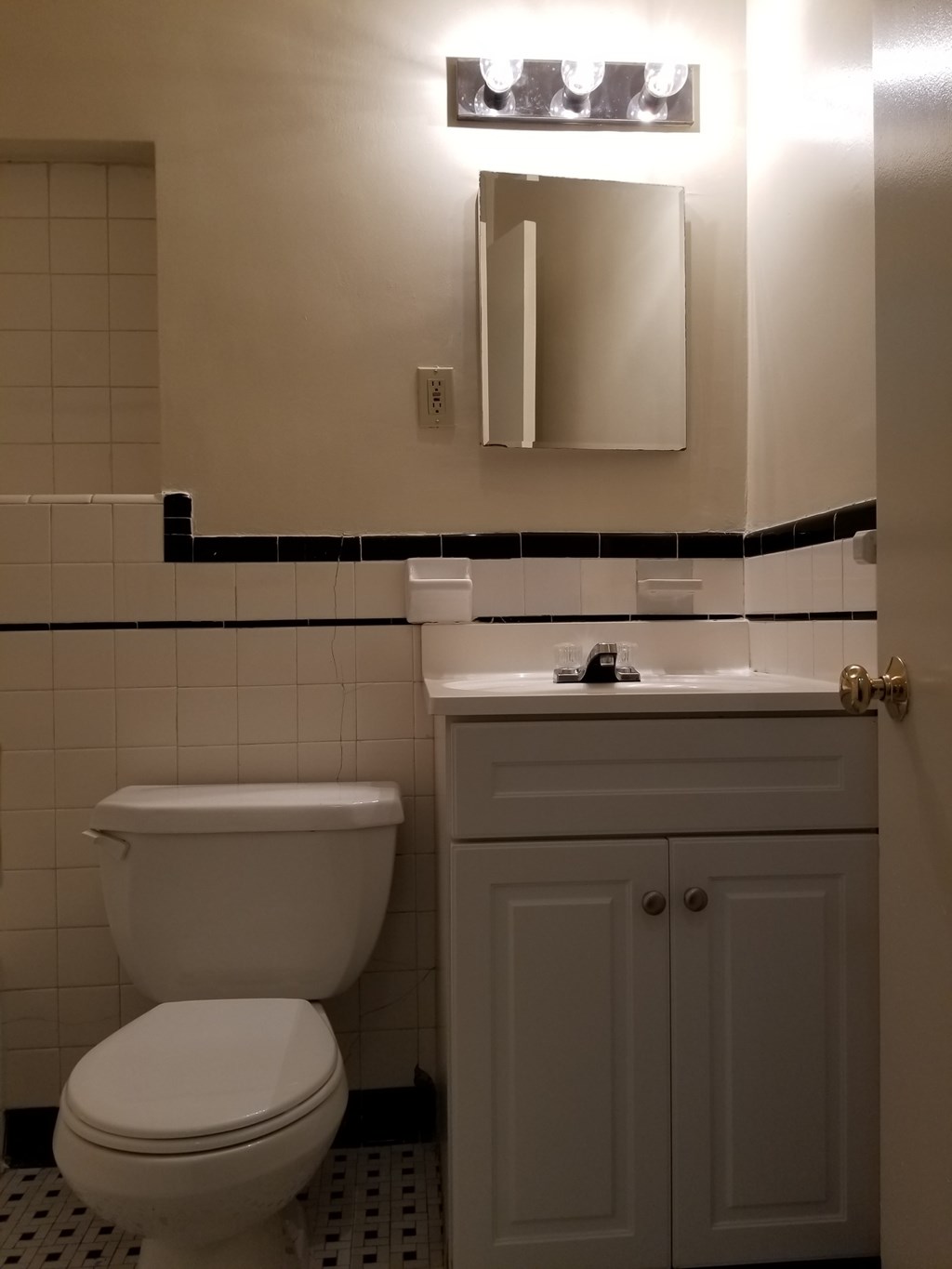 A white toilet sits next to a white sink in a bathroom.
