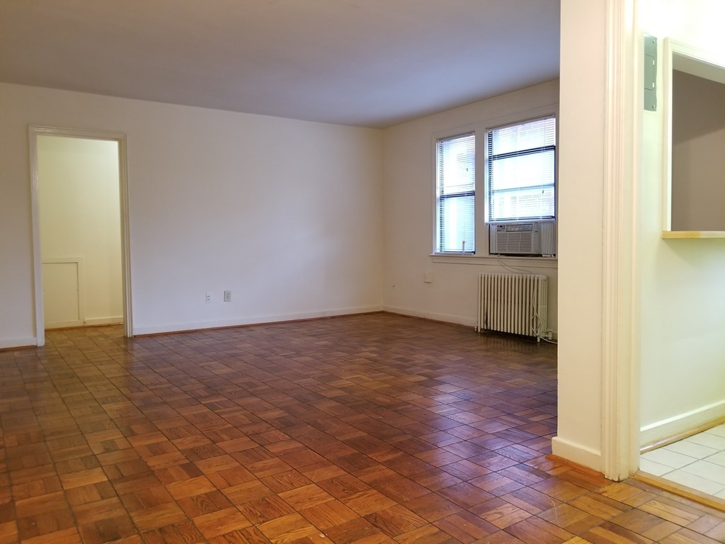 A room with wooden flooring and a window.