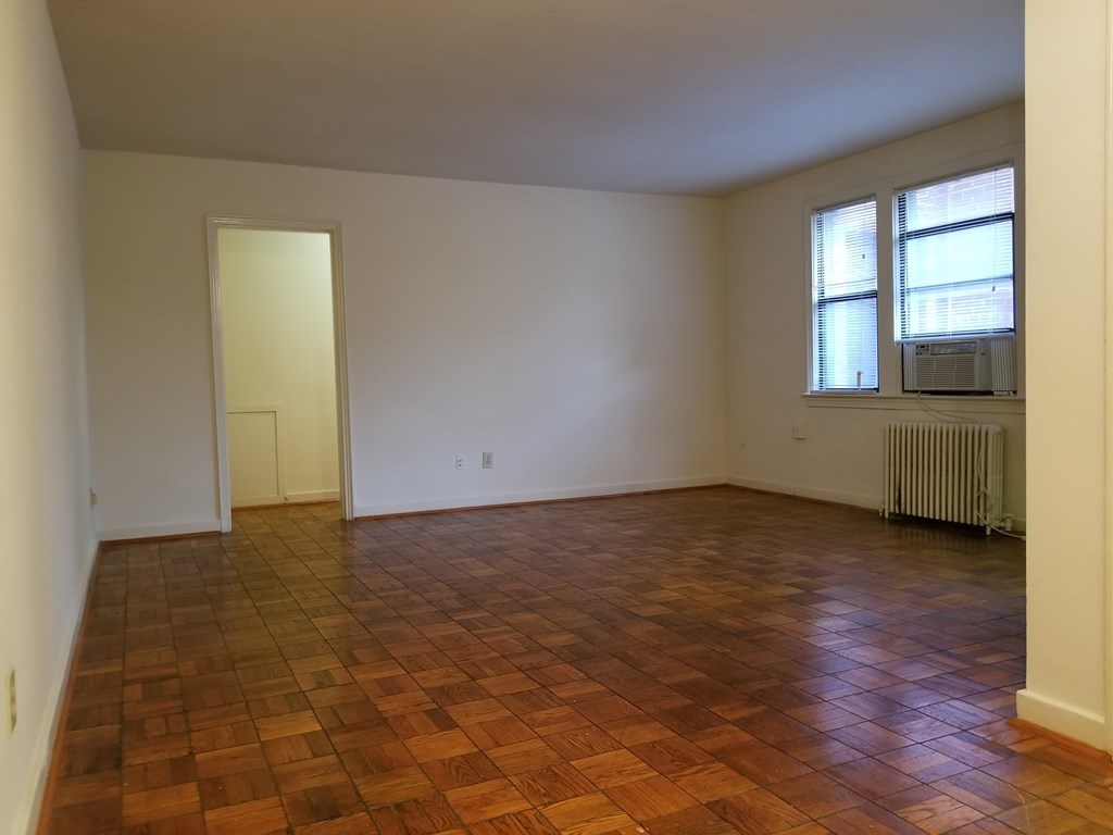 A room with a brown floor and a window.