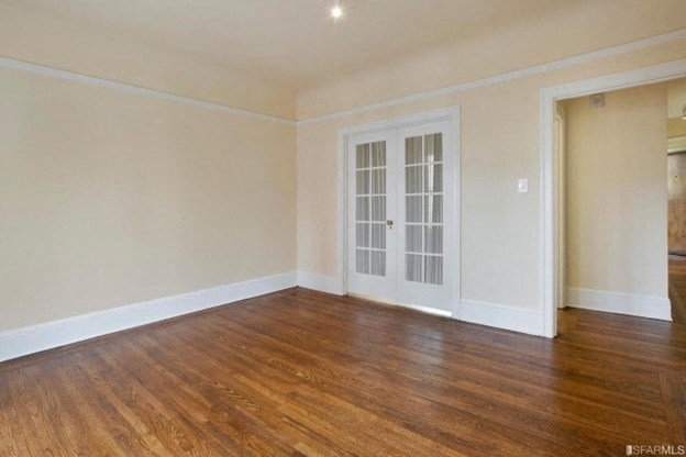 A room with a wooden floor and a white door.