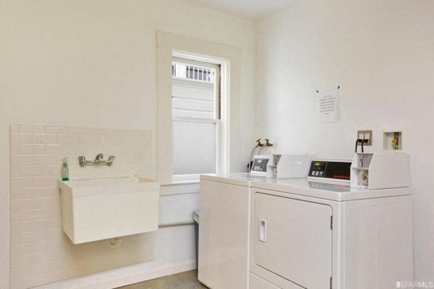 A white bathroom with a sink and a washing machine.