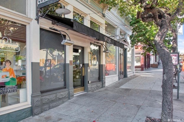 A tree is next to a storefront with a sign that says "SORRY".