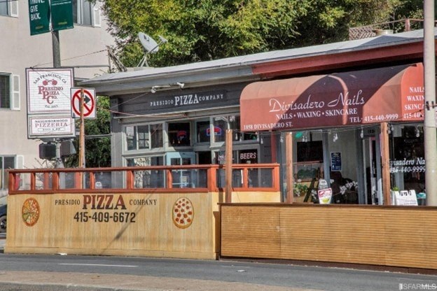 A pizza restaurant with a brown signboard and a red and white striped awning.