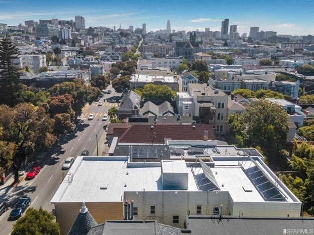 A cityscape with a building in the foreground and a clear sky above.