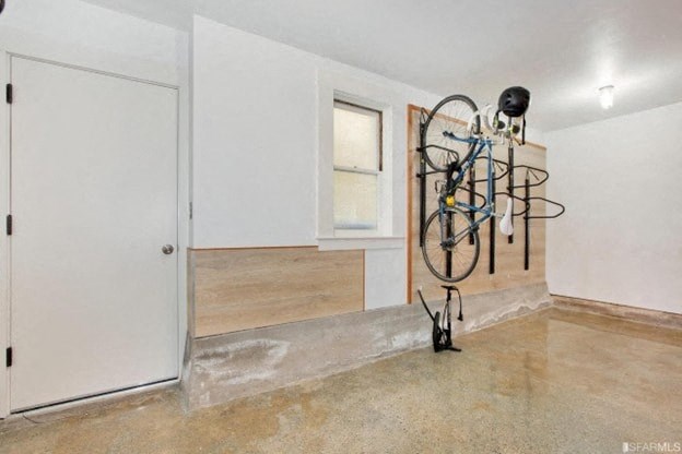 A room with a white door, a window, and a bicycle rack.