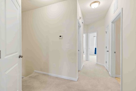 a bedroom and hallway with white walls and a closet