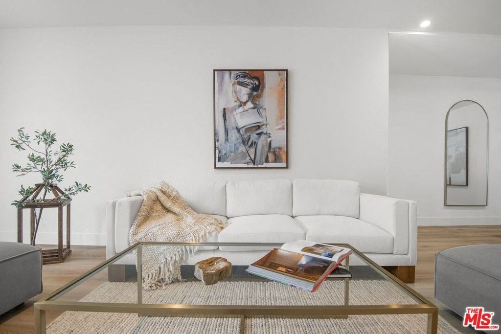 a living room with a white couch and a glass table
