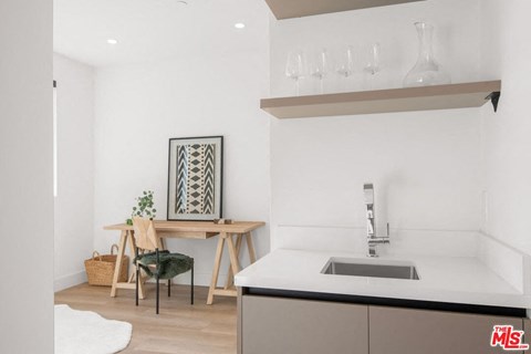 a kitchen with a sink and a table with a chair