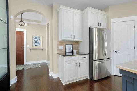 a kitchen with white cabinets and a stainless steel refrigerator