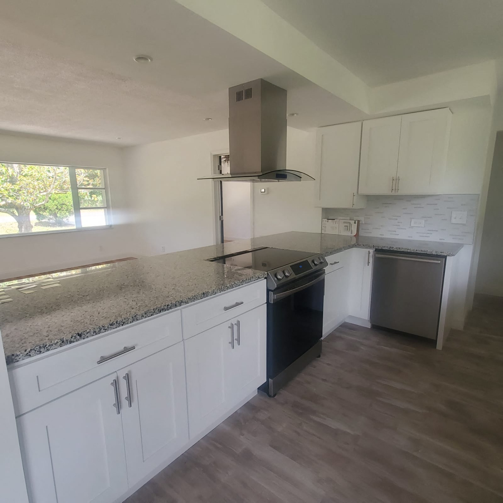 A kitchen with a granite countertop and stainless steel appliances.