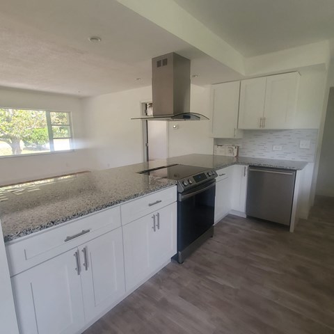 A kitchen with a granite countertop and stainless steel appliances.