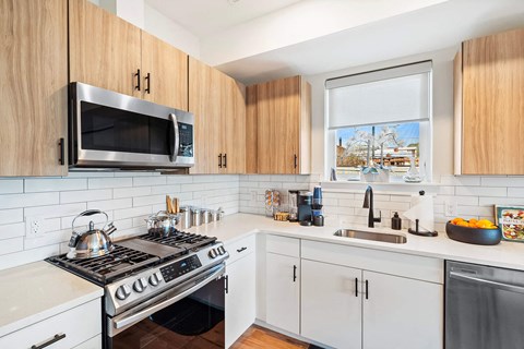 a kitchen with a stove and a sink and a window
