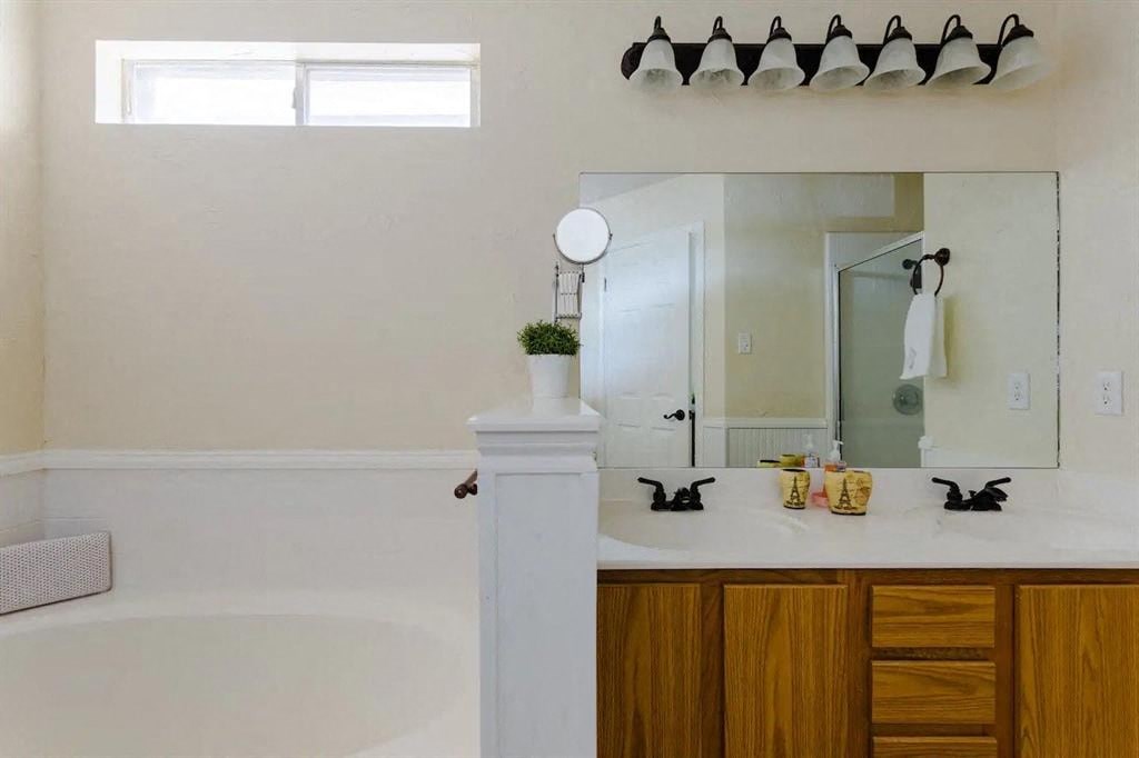 a bathroom with a tub and a sink and a mirror
