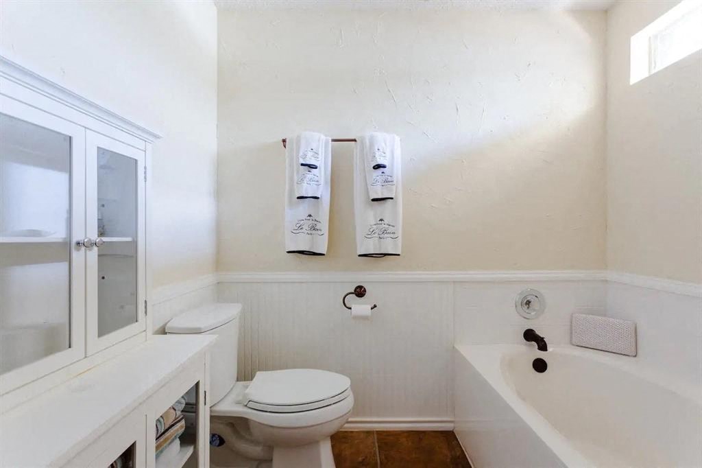 a bathroom with a toilet and a tub and a sink