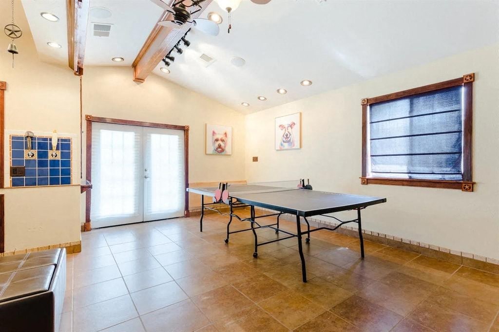 a game room with a ping pong table   and a window