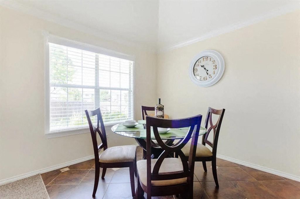 a dining room with a table and chairs and a window