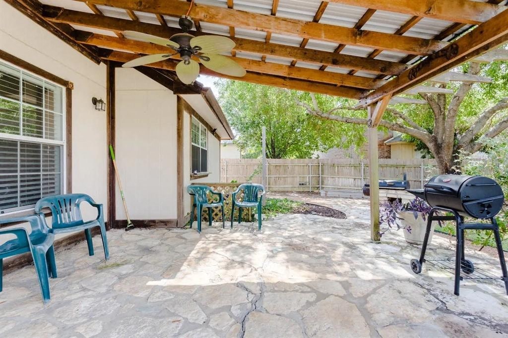 a covered patio with a grill and a table and chairs