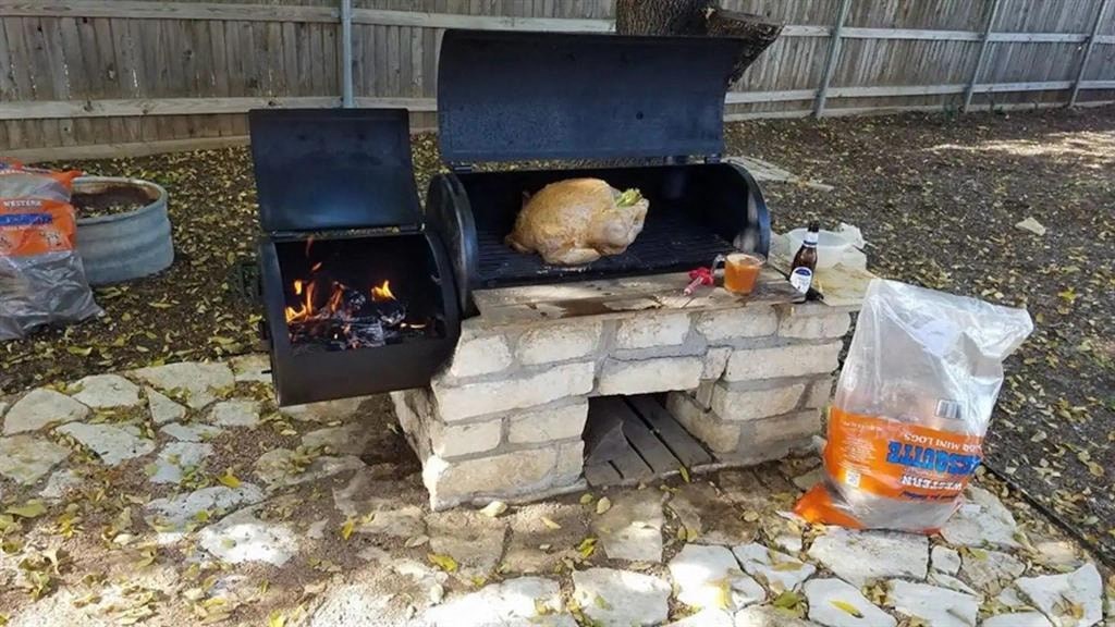 a chicken is sitting on top of a fire pit