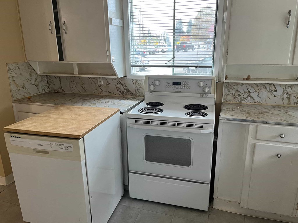 a kitchen with a stove and a window