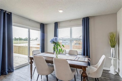 A dining room with a table and chairs.