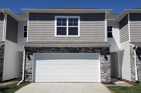 A house with a garage door and a window.