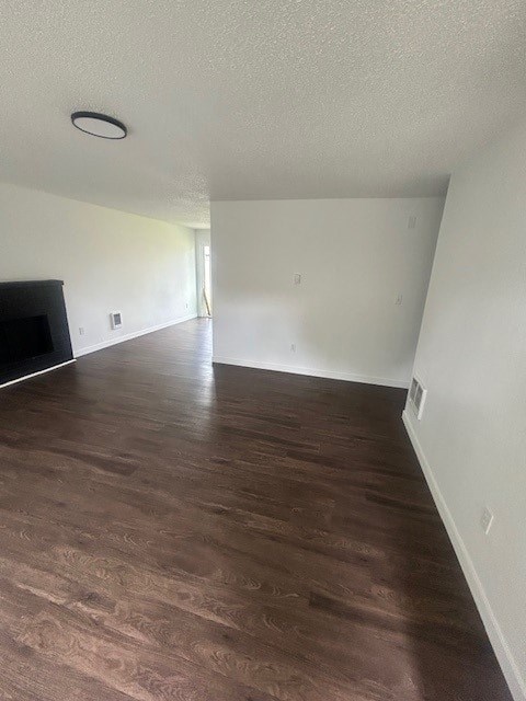 A room with a wooden floor and a flat screen TV mounted on the wall.