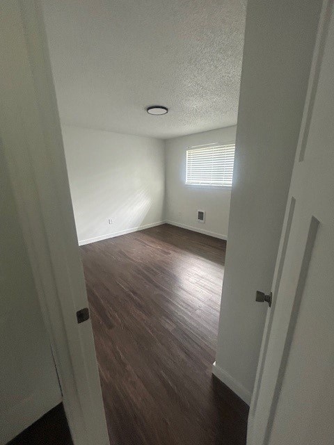 A hallway with wood floors and white walls.