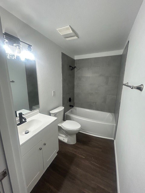 A white bathroom with a toilet, sink, and bathtub.