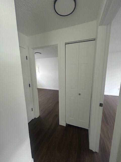 A hallway with white doors and a brown floor.