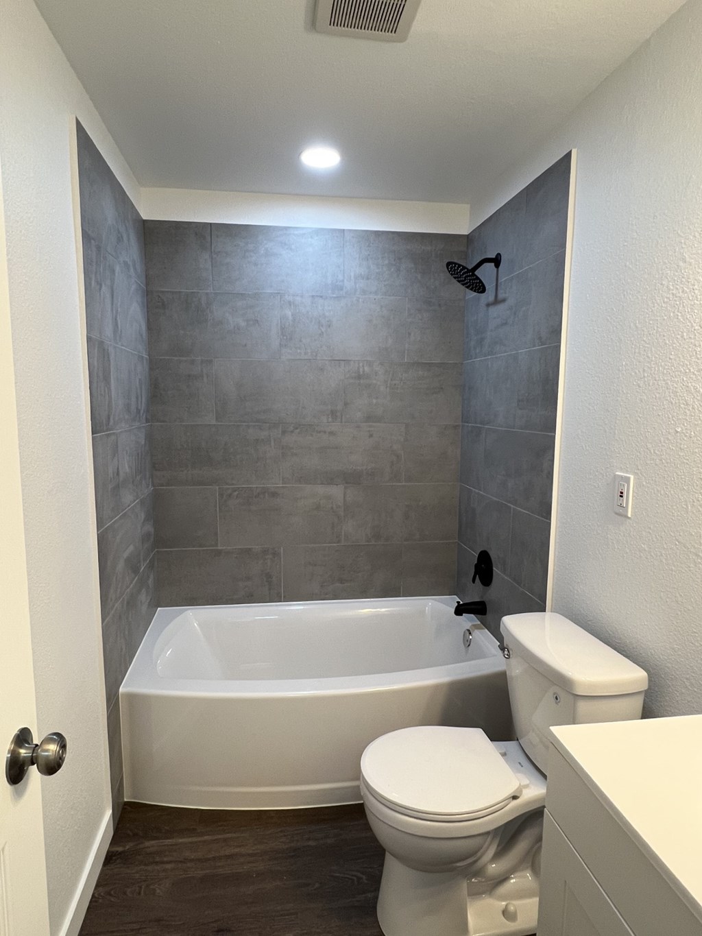 A white toilet sits next to a bathtub in a bathroom.