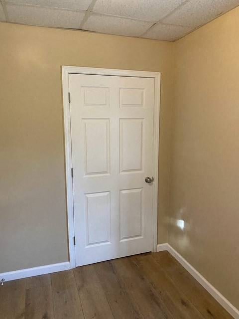 A white door in a room with wooden flooring.