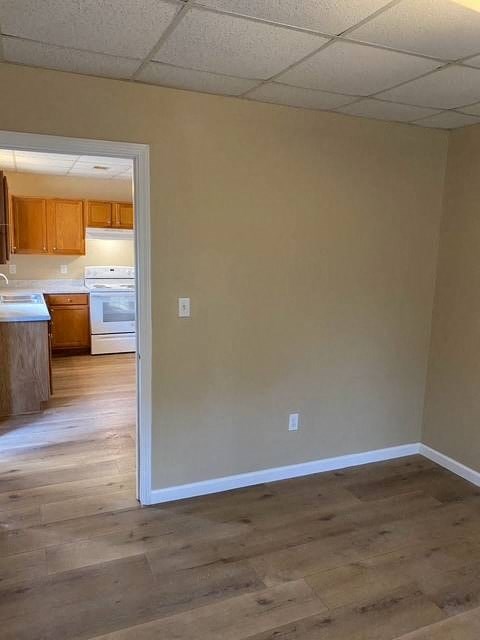 A kitchen with a refrigerator, sink, and cabinets is visible through an open door.