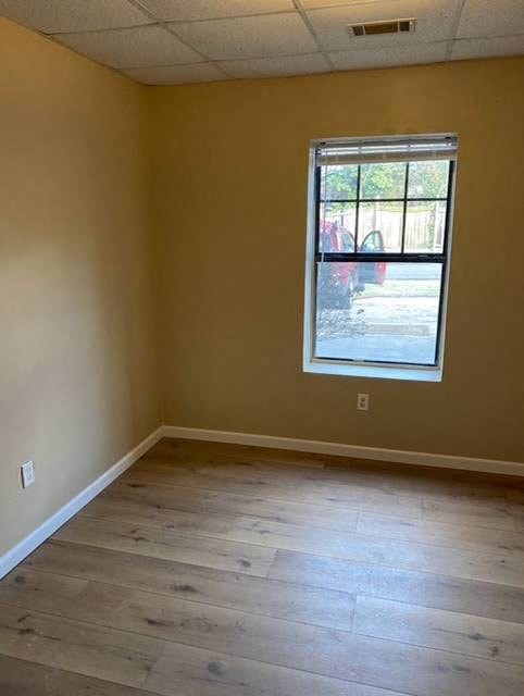 A room with a window and wooden flooring.
