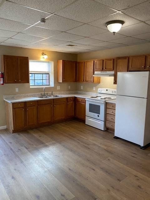 A kitchen with wooden cabinets and a white refrigerator.