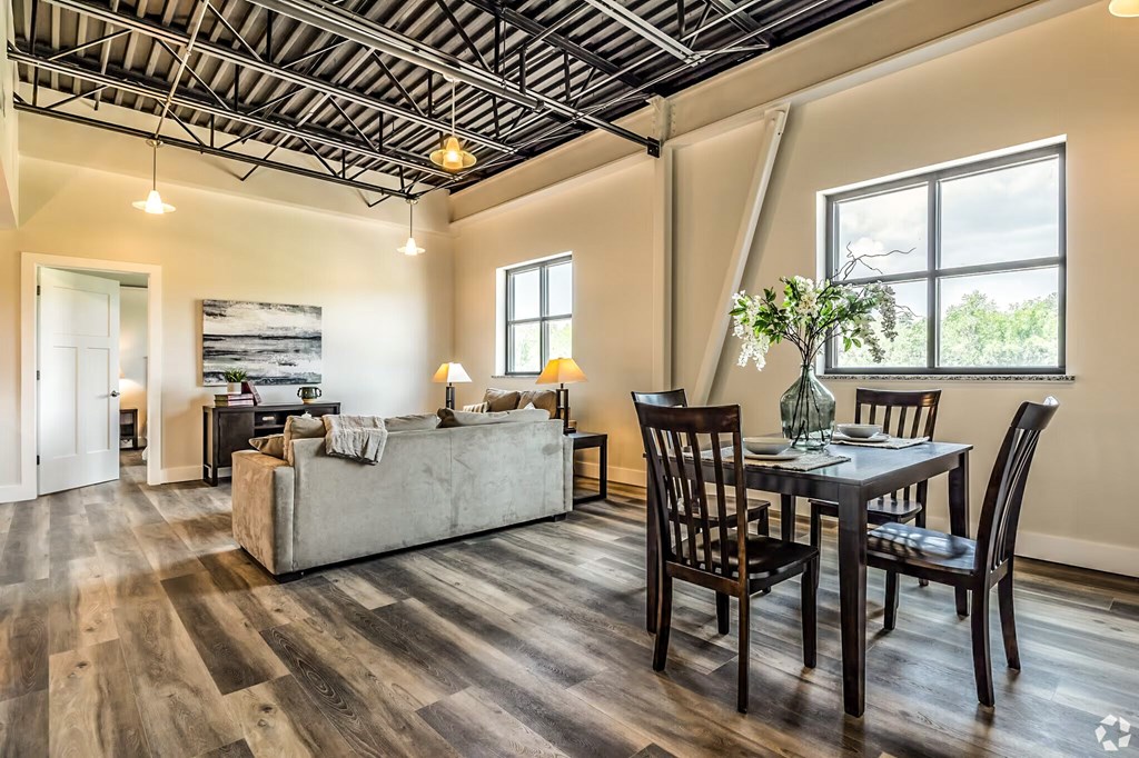 A living room with a couch, chairs, and a dining table.