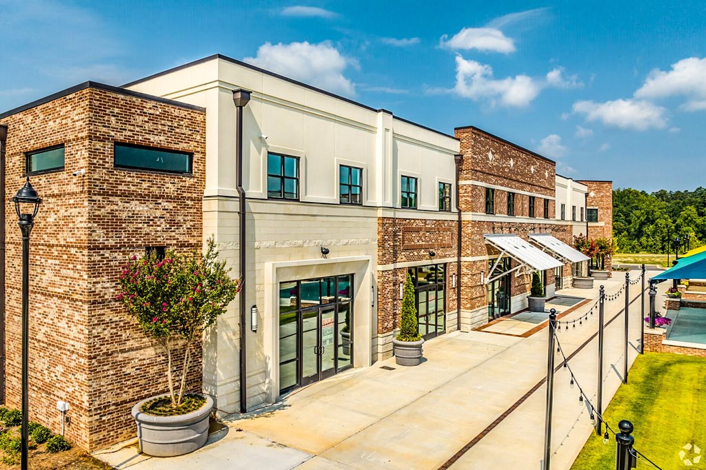 A building with a brick facade and a green lawn in front.