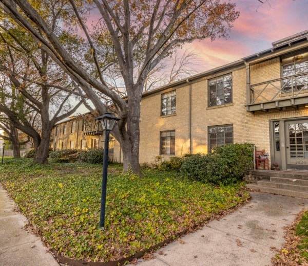 the exterior of a house with trees and a sidewalk
