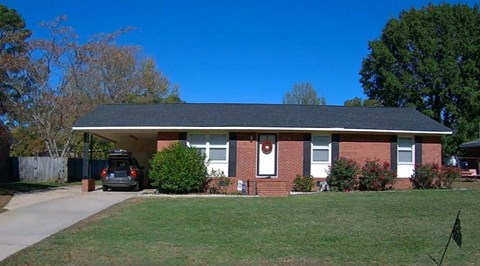 a brick house with a car parked in the driveway