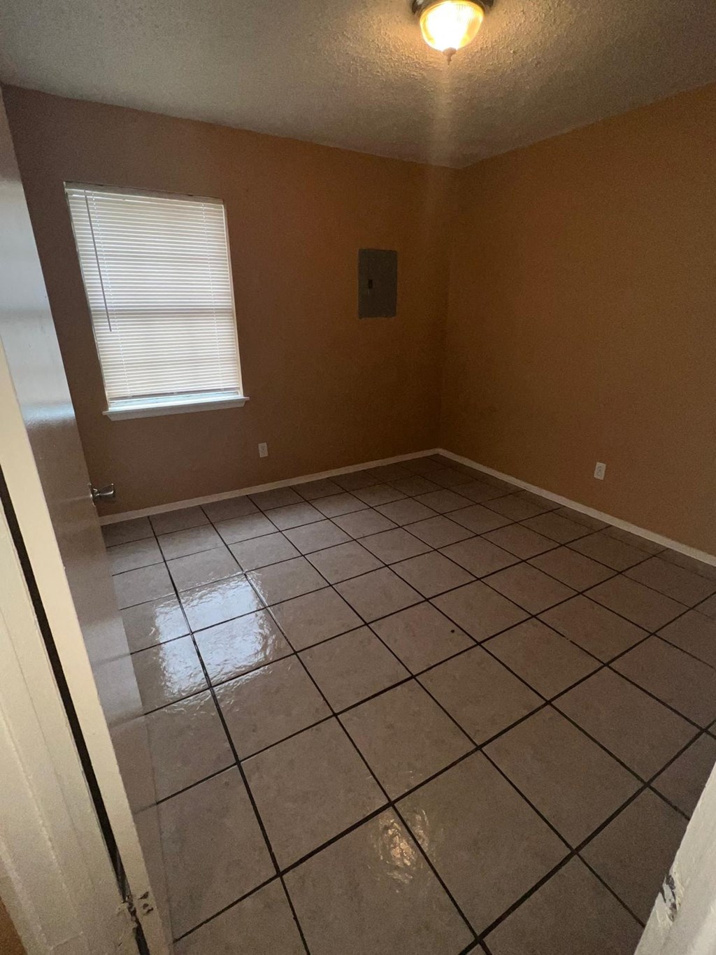 an empty room with a tiled floor and a window