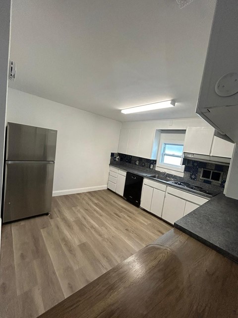 A kitchen with a refrigerator and a window.