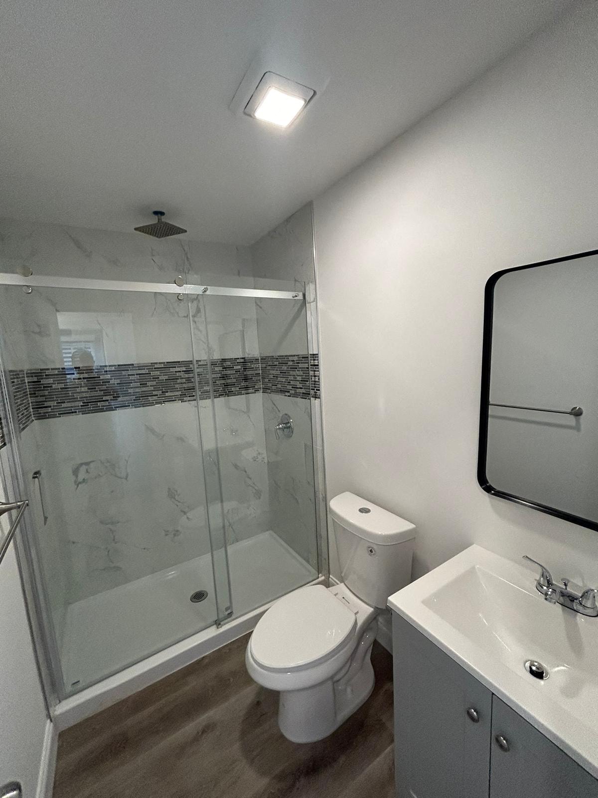 A white toilet sits next to a sink in a bathroom.